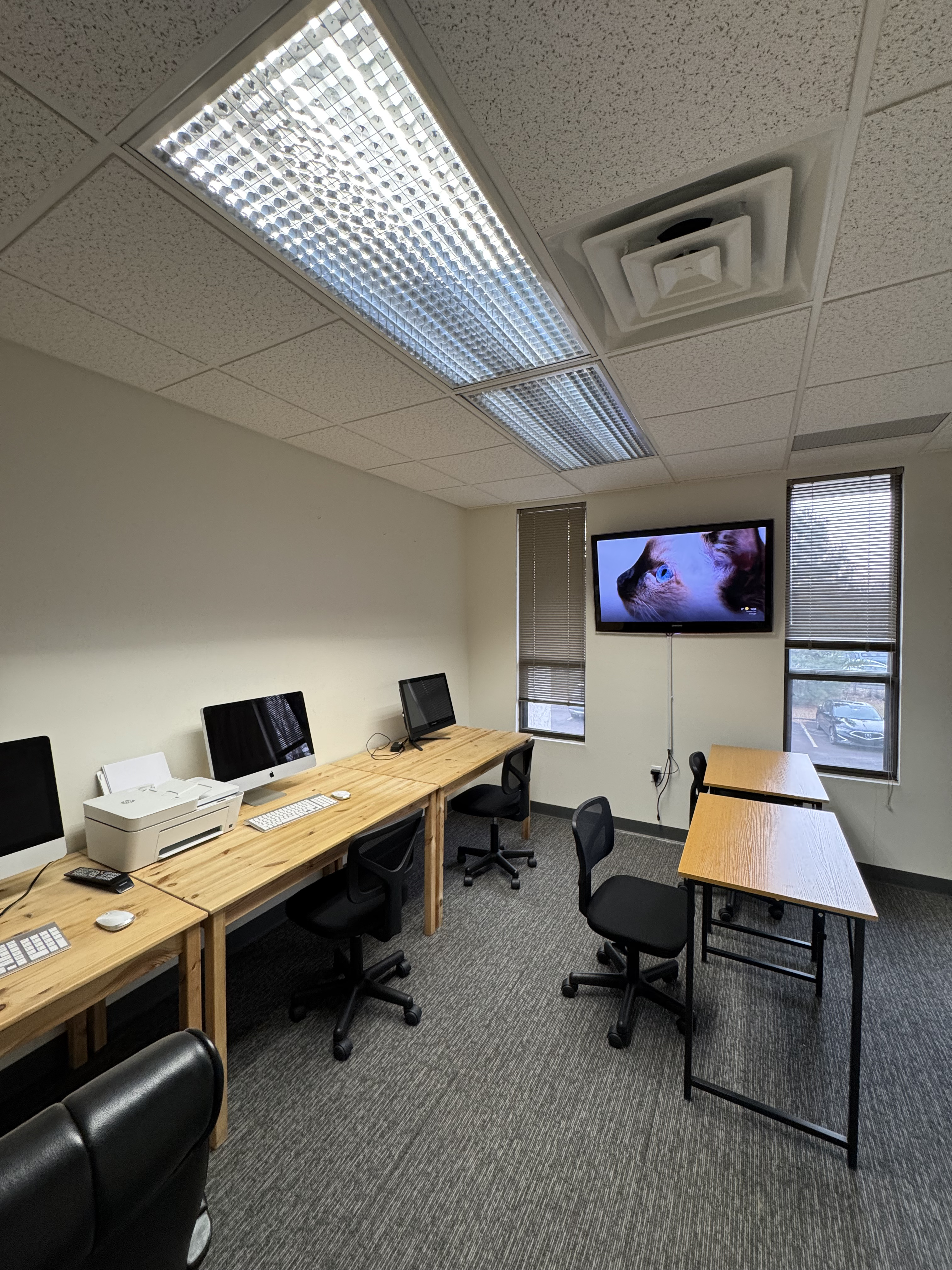 Computing lab with iMac workstations along wooden desks