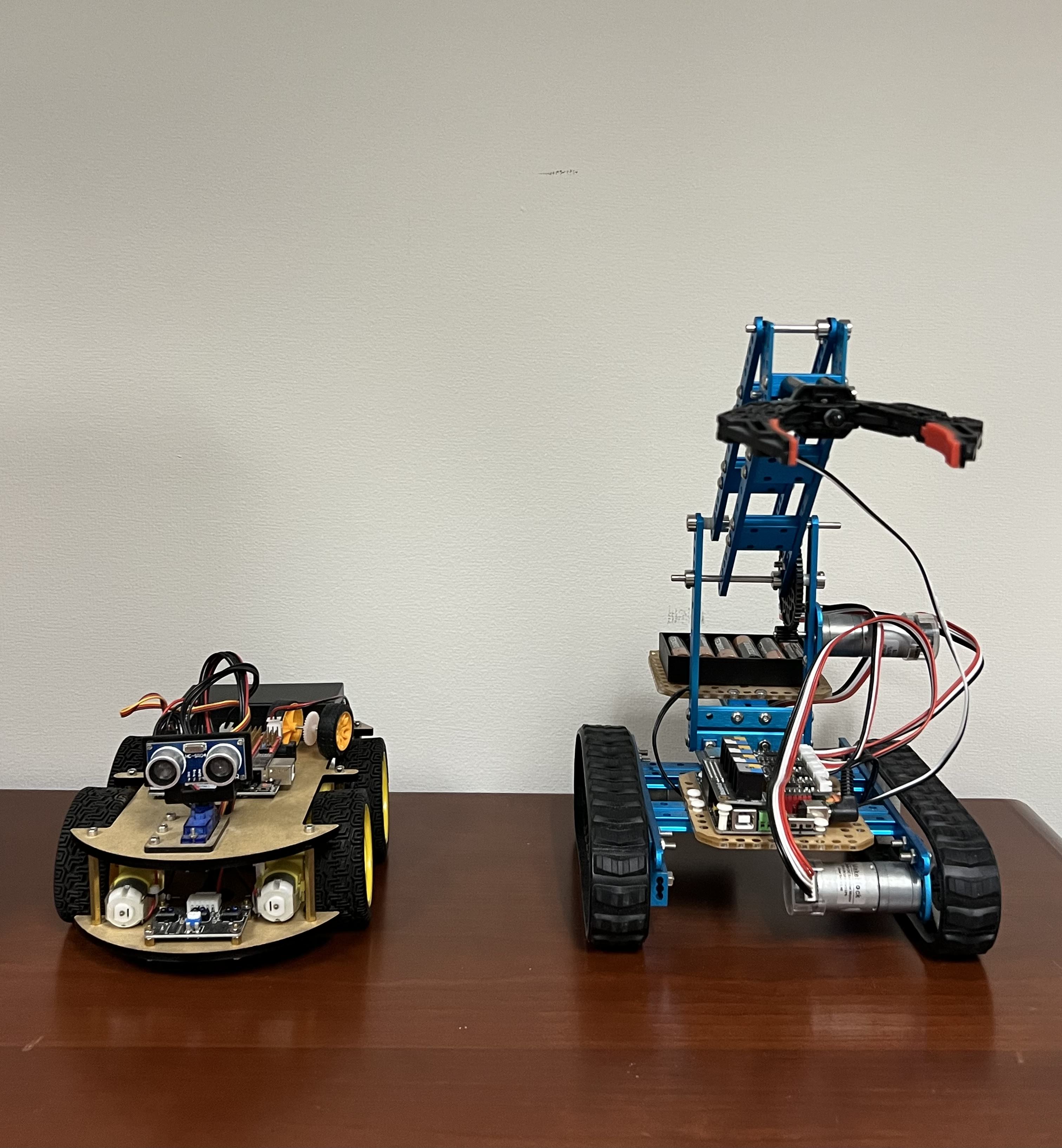 Two student-built mobile robots on a wooden surface